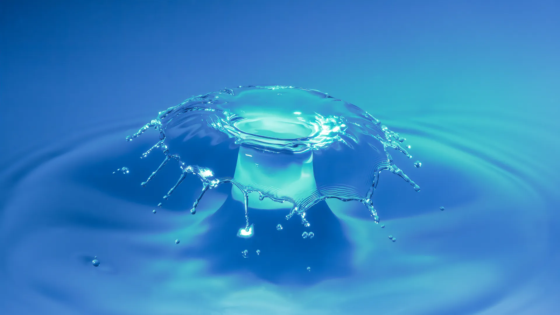 A teal, mushroom-cap-shaped water crown splash.